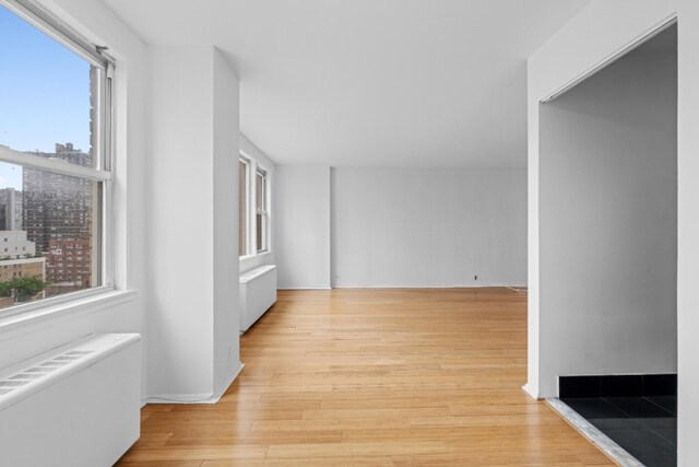 201 E 36th St Unit 14F, New York City, NY 10016 - corridor with radiator and light wood-style floors
