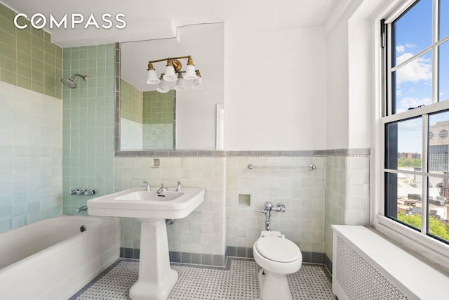 12 E 88th St Unit Ph11/12B, New York City, NY 10128 - full bath with radiator heating unit, tile walls, washtub / shower combination, and toilet