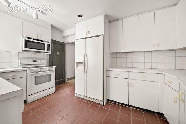 12 E 88th St Unit Ph11/12B, New York City, NY 10128 - kitchen featuring white appliances, light countertops, backsplash, and white cabinets