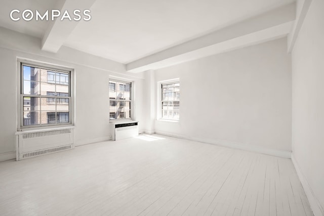 12 E 88th St Unit Ph11/12B, New York City, NY 10128 - unfurnished room with beam ceiling, wood finished floors, and baseboards
