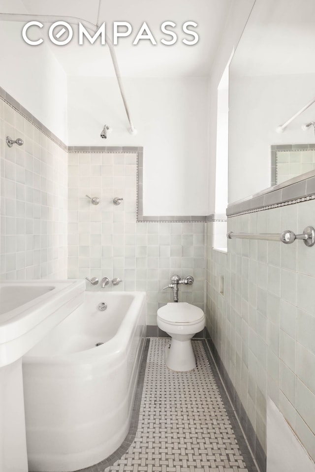 12 E 88th St Unit Ph11/12B, New York City, NY 10128 - bathroom with tile walls, toilet, shower / bath combination, and a wainscoted wall
