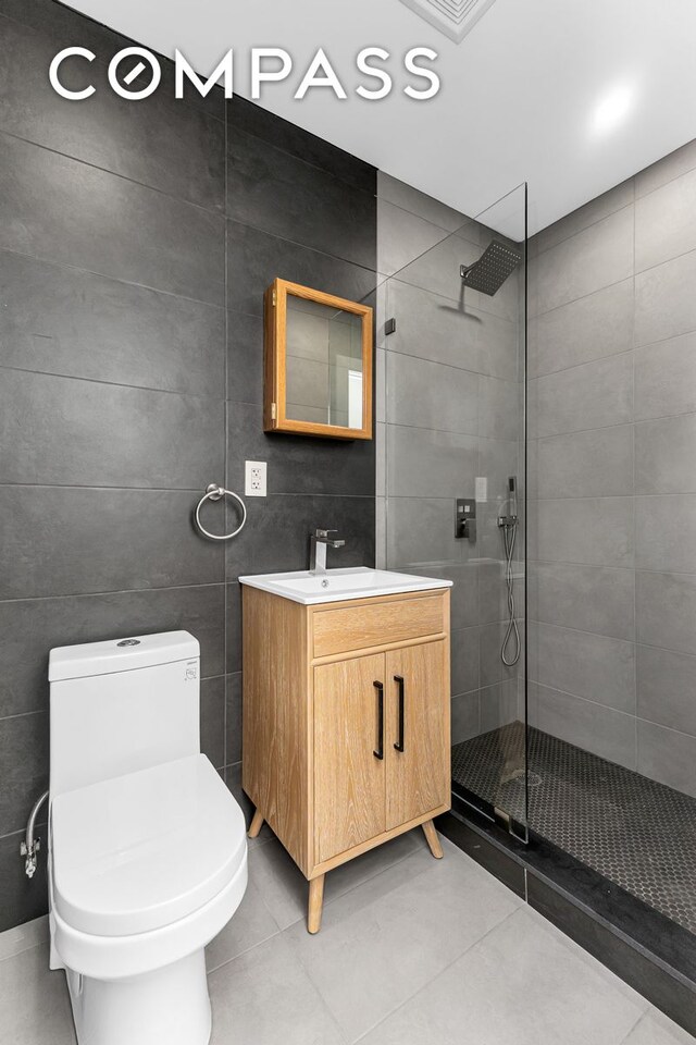 1050 Sterling Place, New York City, NY 11213 - full bathroom with walk in shower, vanity, toilet, tile patterned flooring, and tile walls