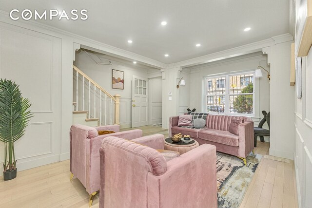1050 Sterling Place, New York City, NY 11213 - living room with a decorative wall, light wood-type flooring, crown molding, and stairs