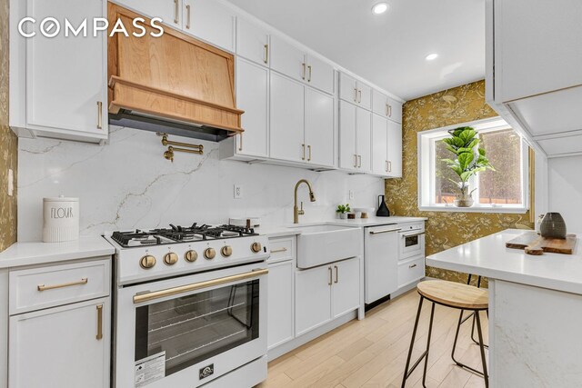 1050 Sterling Place, New York City, NY 11213 - kitchen with white gas range, custom range hood, a sink, light countertops, and white cabinetry