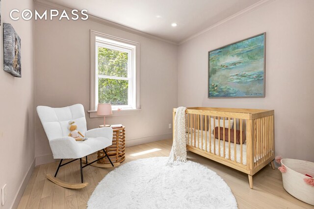 1050 Sterling Place, New York City, NY 11213 - bedroom featuring ornamental molding, wood finished floors, baseboards, a crib, and recessed lighting