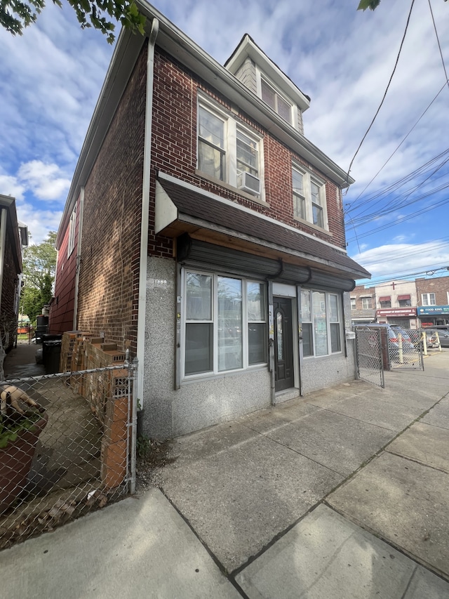 1409 E 92nd St, New York City, NY 11236 - view of front facade with brick siding, a gate, and cooling unit