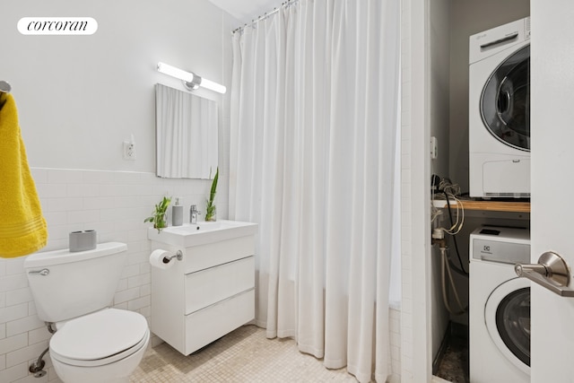 305 E 24th Street Lf, New York City, NY 10010 - washroom with stacked washer / dryer, tile walls, and a wainscoted wall
