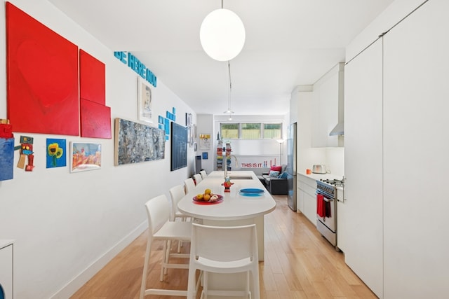 305 E 24th Street Lf, New York City, NY 10010 - kitchen featuring appliances with stainless steel finishes, light wood-style floors, light countertops, and white cabinets