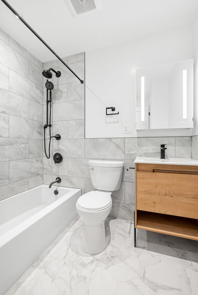 113 W 13th Street Building, New York City, NY 10011 - bathroom featuring bathing tub / shower combination, toilet, vanity, marble look tiles, and tile walls