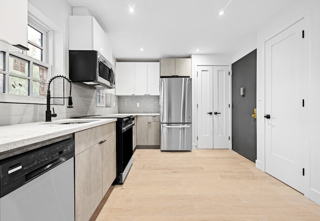 113 W 13th Street Building, New York City, NY 10011 - kitchen featuring stainless steel appliances, decorative backsplash, a sink, light wood-style flooring, and modern cabinets