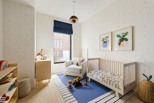 207 N 5th St Ph, Ph, New York City, NY 11211 - bedroom with wood finished floors, wallpapered walls, and a nursery area
