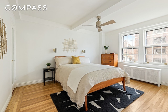 24 Monroe Pl Unit 7D, New York City, NY 11201 - bedroom featuring radiator heating unit, light wood-style floors, beam ceiling, baseboards, and ceiling fan