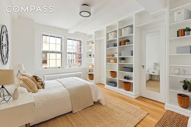 24 Monroe Pl Unit 7D, New York City, NY 11201 - bedroom featuring radiator, light wood finished floors, and beam ceiling