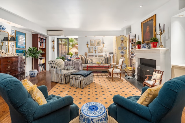 56 W 71st St Unit 1B, New York City, NY 10023 - living area featuring a wall mounted AC, wood finished floors, and a fireplace with flush hearth