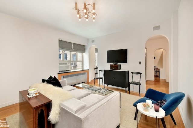165 W 20th St Unit 6F, New York City, NY 10011 - living room with radiator, arched walkways, wood finished floors, and baseboards