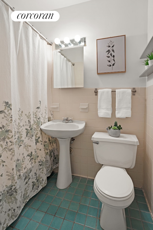 111 E 10th St Unit 20, New York City, NY 10003 - full bathroom with tile patterned floors, toilet, tile walls, wainscoting, and a shower with shower curtain