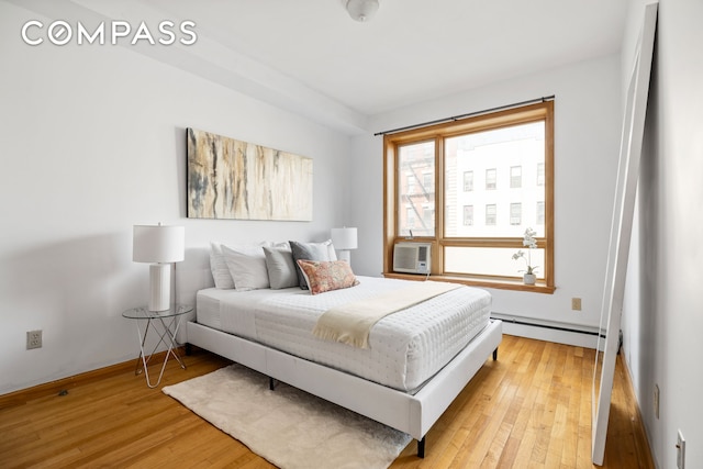 228 Bushwick Ave Unit 3B, New York City, NY 11206 - bedroom featuring a baseboard radiator, light wood finished floors, and cooling unit