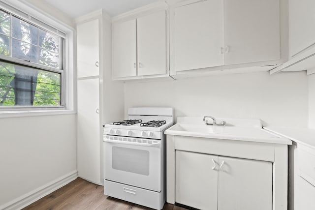 601 E 19th St Unit 3O, New York City, NY 11226 - kitchen featuring white range with gas stovetop, white cabinets, wood finished floors, and light countertops