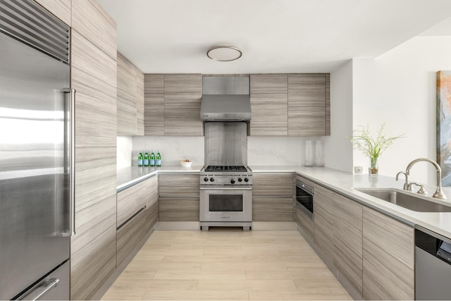 155 W 11th St Unit 14D, New York City, NY 10011 - kitchen with high quality appliances, wall chimney range hood, a sink, modern cabinets, and light countertops