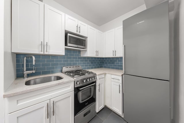 220 E 67th St Unit 11F, New York City, NY 10065 - kitchen featuring appliances with stainless steel finishes, a sink, white cabinetry, and backsplash