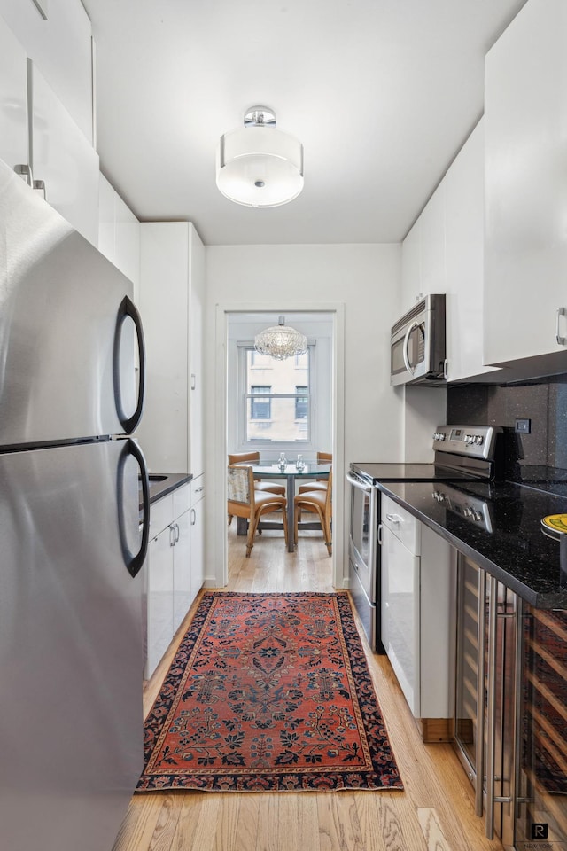433 E 56th St Unit 6-B, New York City, NY 10022 - kitchen with stainless steel appliances, white cabinetry, and light wood-type flooring