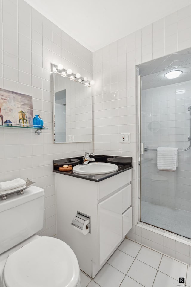 433 E 56th St Unit 6-B, New York City, NY 10022 - bathroom featuring tile walls, vanity, a stall shower, toilet, and tile patterned floors