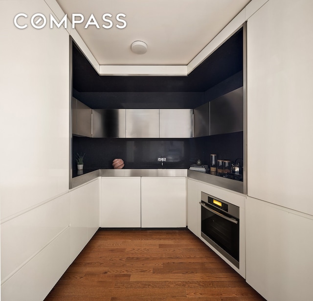 15 William St Unit 7H, New York City, NY 10005 - kitchen featuring oven, open shelves, white cabinetry, dark wood-style flooring, and modern cabinets
