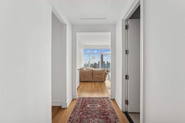 151 E 58th St Unit 42C, New York City, NY 10022 - hall featuring light wood finished floors, attic access, and baseboards