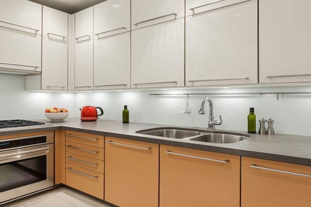 151 E 58th St Unit 42C, New York City, NY 10022 - kitchen with stainless steel appliances, a sink, white cabinets, and dark countertops