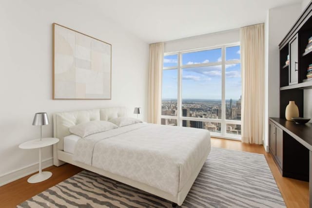 151 E 58th St Unit 42C, New York City, NY 10022 - bedroom with light wood-type flooring and baseboards