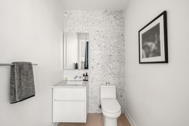 128 W 23rd St Unit 15B, New York City, NY 10011 - half bath featuring vanity, toilet, and wood finished floors