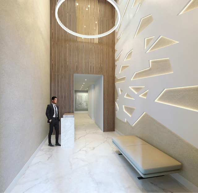 128 W 23rd St Unit 15B, New York City, NY 10011 - hallway featuring a high ceiling, marble finish floors, and baseboards