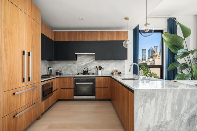 128 W 23rd St Unit 15B, New York City, NY 10011 - kitchen with appliances with stainless steel finishes, modern cabinets, light stone counters, backsplash, and light wood-style flooring