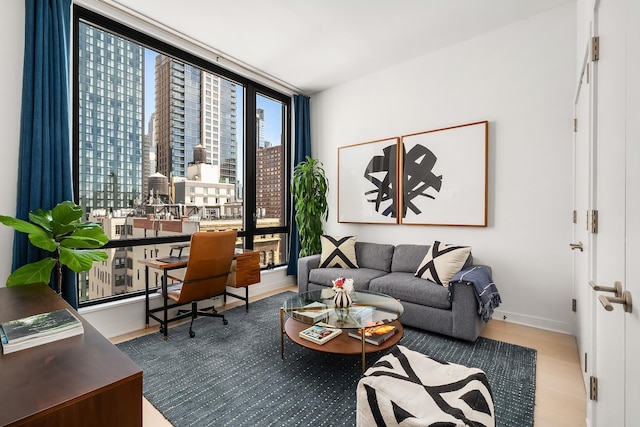 128 W 23rd St Unit 15B, New York City, NY 10011 - living area featuring expansive windows, baseboards, wood finished floors, a desk, and a view of city