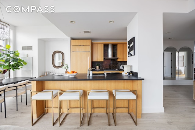 70 Little W St Unit 7L, New York City, NY 10004 - kitchen with wall chimney range hood, tasteful backsplash, modern cabinets, and dark countertops