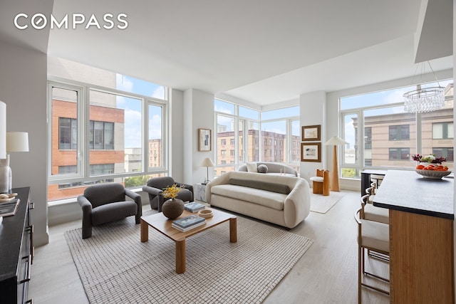70 Little W St Unit 7L, New York City, NY 10004 - living room featuring light wood-type flooring and a chandelier