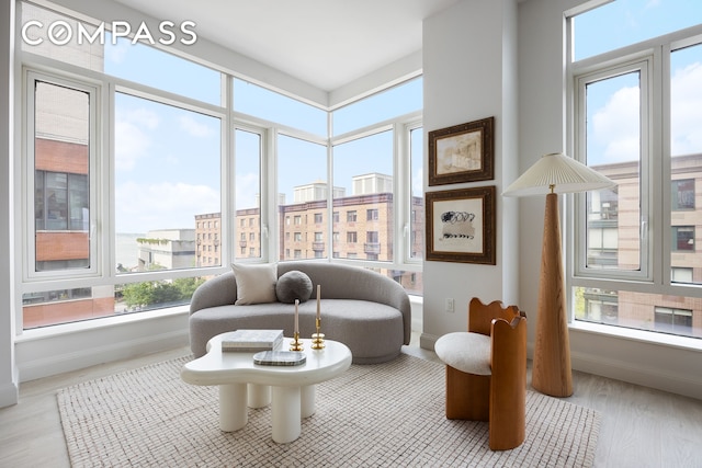 70 Little W St Unit 7L, New York City, NY 10004 - living area featuring healthy amount of natural light, baseboards, and wood finished floors