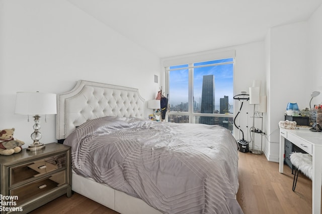 460 W 42nd St Unit 58G, New York City, NY 10036 - bedroom with light wood-type flooring and a skyline view