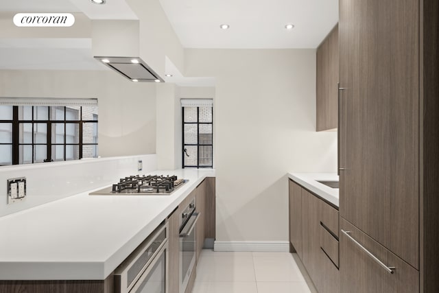 10 Park Ave Unit 3Ab, New York City, NY 10016 - kitchen with modern cabinets, appliances with stainless steel finishes, exhaust hood, light countertops, and light tile patterned flooring