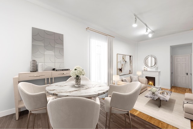 2 W 90th St Unit 2C, New York City, NY 10024 - dining area featuring a warm lit fireplace, rail lighting, wood finished floors, baseboards, and ornamental molding