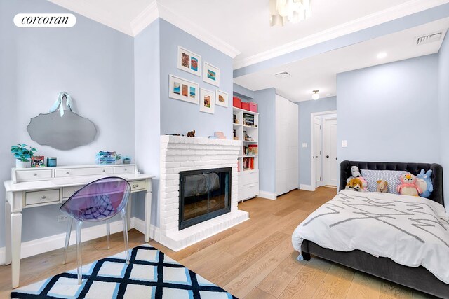 213 E 71st St Unit Ph5, New York City, NY 10021 - bedroom featuring crown molding, light wood finished floors, baseboards, and a brick fireplace