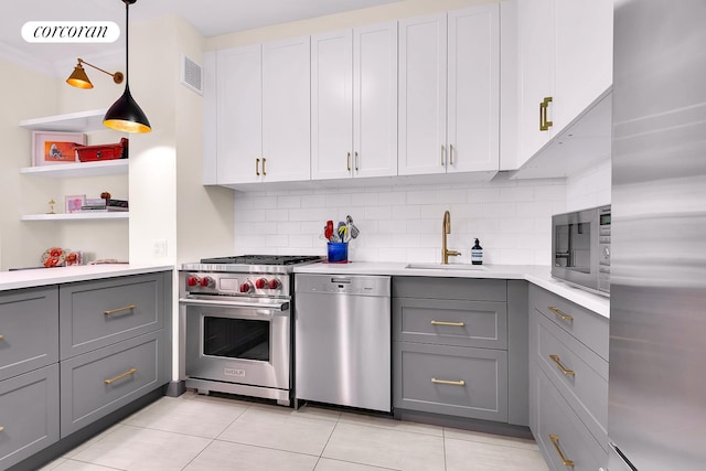 213 E 71st St Unit Ph5, New York City, NY 10021 - kitchen with appliances with stainless steel finishes, gray cabinetry, a sink, light countertops, and tasteful backsplash