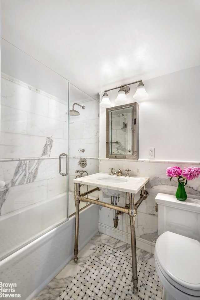 340 E 80th St Unit 17F, New York City, NY 10075 - full bathroom with enclosed tub / shower combo, toilet, tile walls, and marble finish flooring
