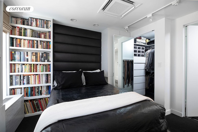 240 E 24th St Unit 4B, New York City, NY 10010 - bedroom with rail lighting, a closet, a walk in closet, and baseboards
