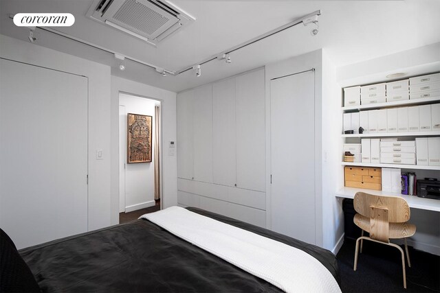 240 E 24th St Unit 4B, New York City, NY 10010 - bedroom with track lighting, dark carpet, and an office area