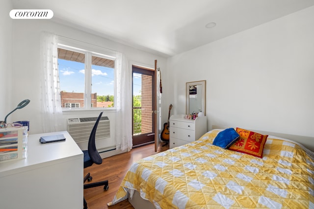 46-12 161st St Unit 3B, New York City, NY 11358 - bedroom with wood finished floors, an AC wall unit, a desk, and access to exterior