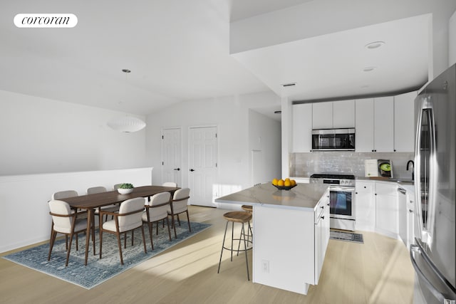 3-17 Endeavor Pl Unit C, New York City, NY 11356 - kitchen with stainless steel appliances, light wood finished floors, a sink, tasteful backsplash, and a kitchen breakfast bar