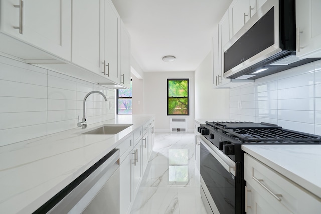 41-12 41st St Unit 2N, New York City, NY 11104 - kitchen featuring stainless steel appliances, light marble finish floors, a sink, and tasteful backsplash