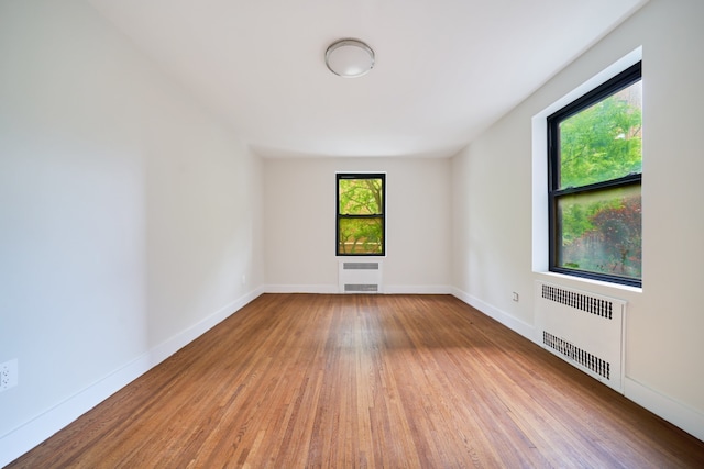 41-12 41st St Unit 2N, New York City, NY 11104 - unfurnished room featuring radiator heating unit, wood finished floors, and baseboards
