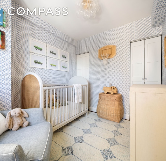 200 E 16th St Unit 14C, New York City, NY 10003 - bedroom featuring wallpapered walls, two closets, baseboards, and a crib